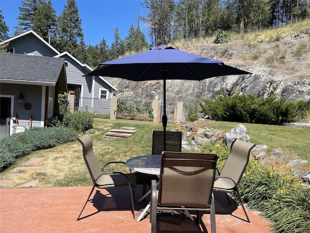 view of patio featuring outdoor dining space and fence