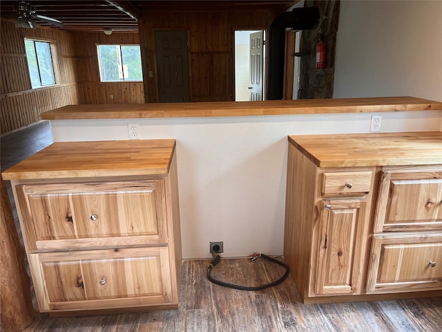 kitchen featuring butcher block countertops, wood walls, dark wood-type flooring, and ceiling fan