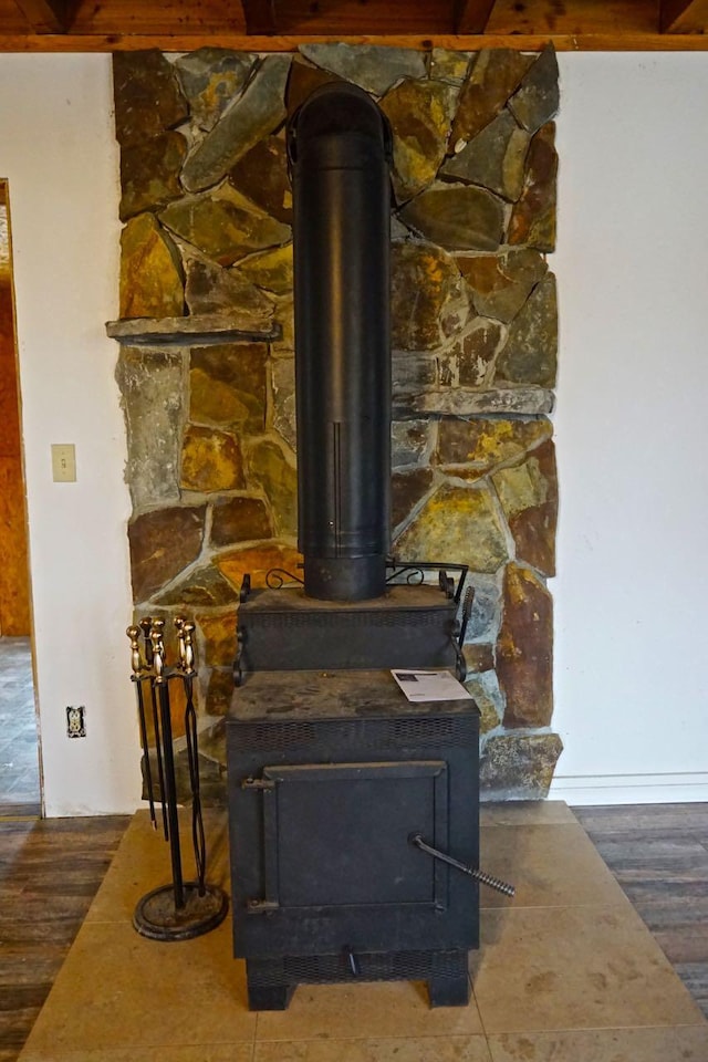 room details featuring a wood stove and dark wood-type flooring