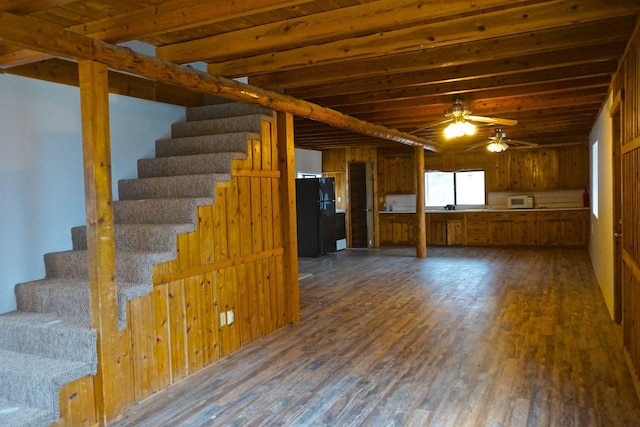 basement with dark hardwood / wood-style flooring, ceiling fan, and black refrigerator