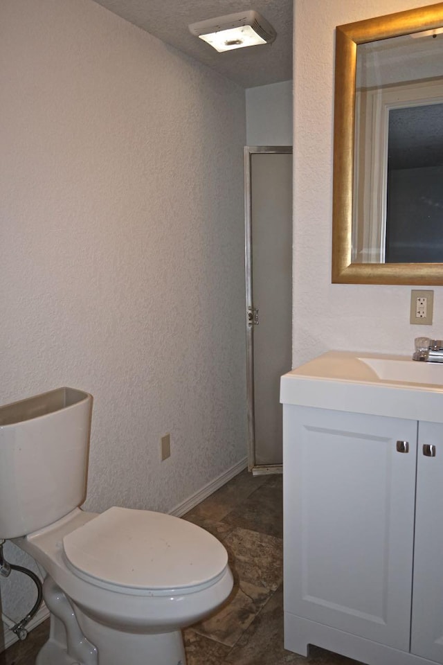 bathroom featuring tile flooring, vanity, and toilet