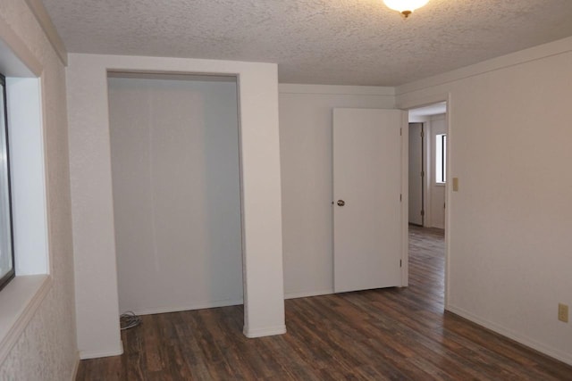 unfurnished bedroom with dark hardwood / wood-style flooring, a closet, and a textured ceiling