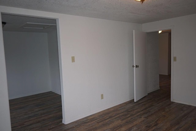 unfurnished room with a textured ceiling and dark hardwood / wood-style flooring