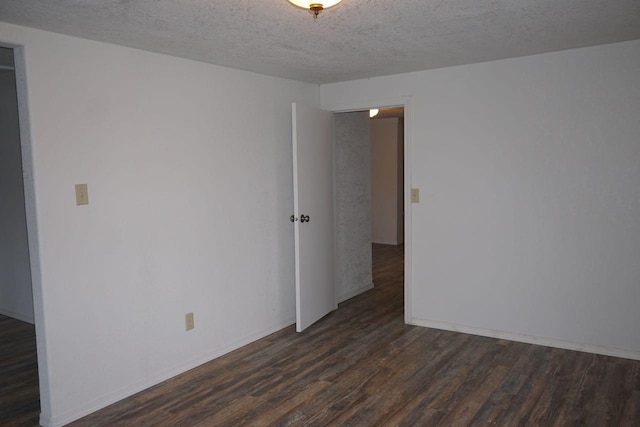 unfurnished room featuring a textured ceiling and dark wood-type flooring