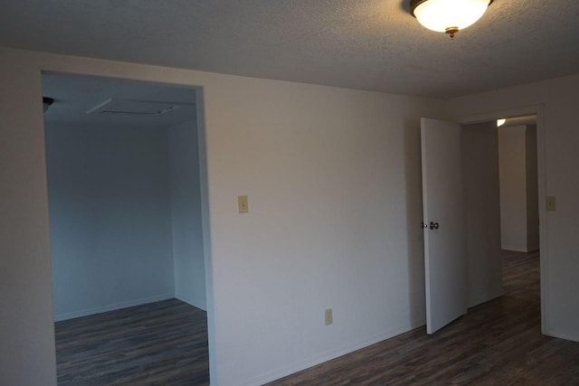 unfurnished room featuring a textured ceiling and dark wood-type flooring