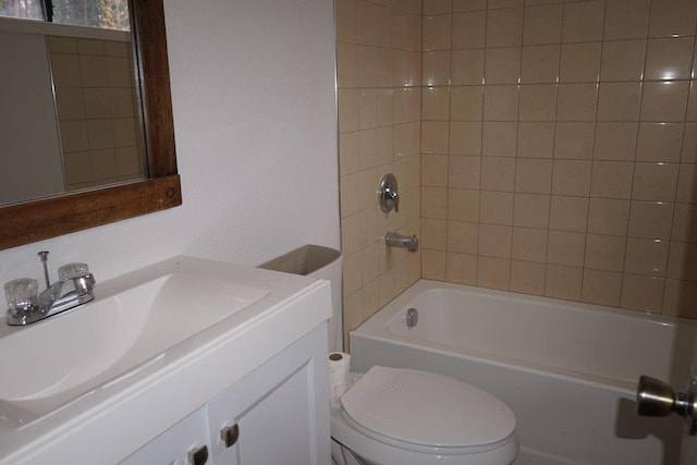 full bathroom featuring tiled shower / bath combo, toilet, and vanity