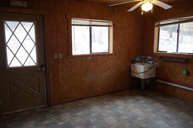 foyer entrance with a healthy amount of sunlight, dark tile floors, and ceiling fan