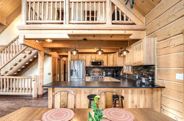 kitchen featuring light brown cabinets, dark wood-type flooring, stainless steel appliances, pendant lighting, and lofted ceiling with beams