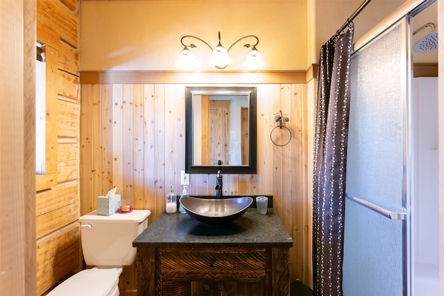 bathroom featuring vanity, toilet, and wood walls