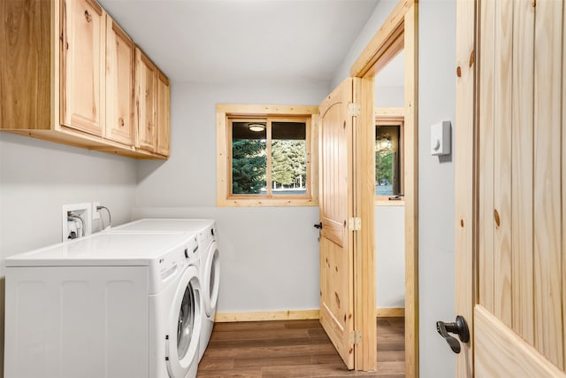 laundry area featuring separate washer and dryer, cabinets, and hardwood / wood-style floors