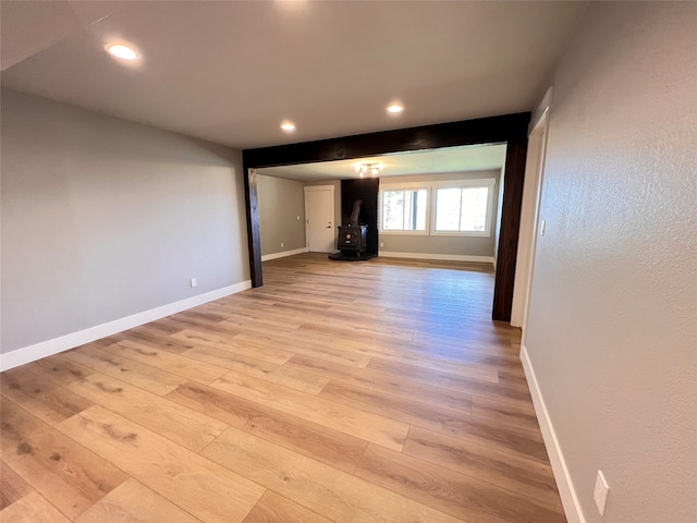 empty room featuring light wood-type flooring and a wood stove