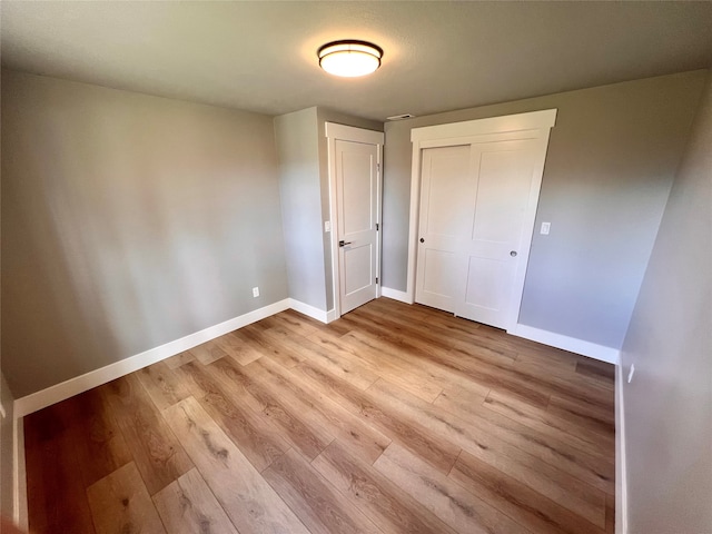 unfurnished bedroom with light hardwood / wood-style floors and a closet