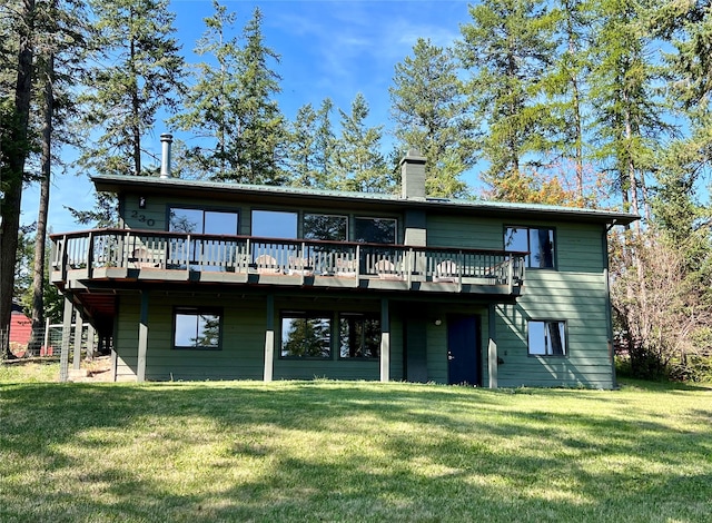 rear view of house with a deck and a yard