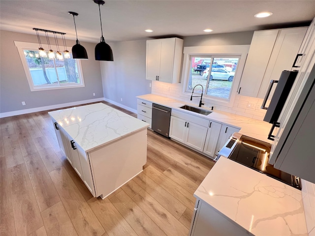 kitchen with stainless steel dishwasher, a kitchen island, sink, white cabinetry, and hanging light fixtures