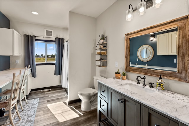 bathroom featuring vanity, toilet, and hardwood / wood-style floors