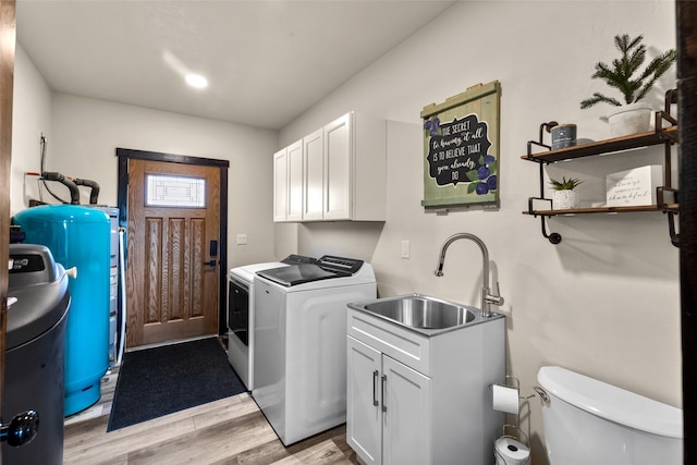 washroom featuring sink, light wood-type flooring, and washer and dryer