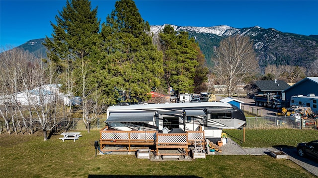 view of dock with a deck with mountain view and a lawn