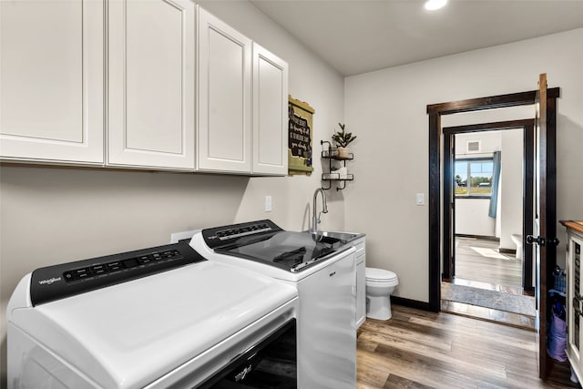 laundry area featuring sink, dark hardwood / wood-style flooring, and washing machine and clothes dryer