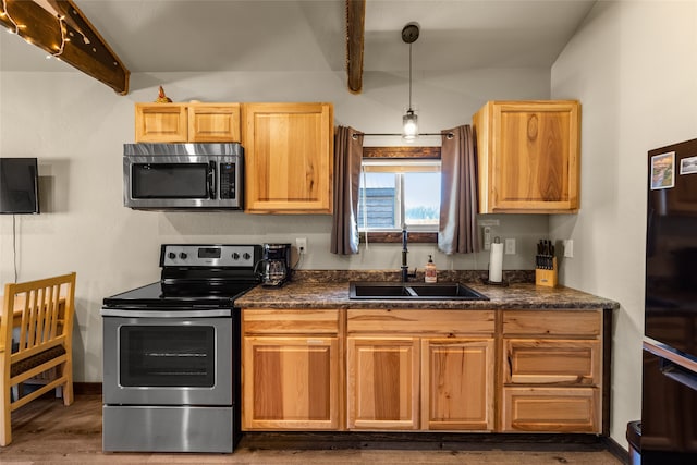 kitchen featuring appliances with stainless steel finishes, sink, hardwood / wood-style flooring, lofted ceiling with beams, and decorative light fixtures