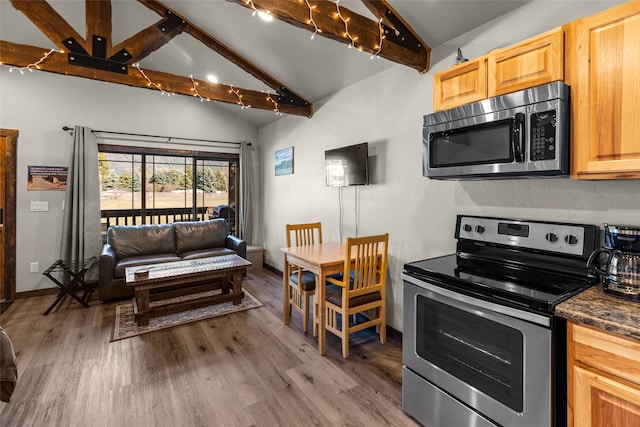 kitchen featuring light brown cabinets, lofted ceiling with beams, stainless steel appliances, and light hardwood / wood-style floors