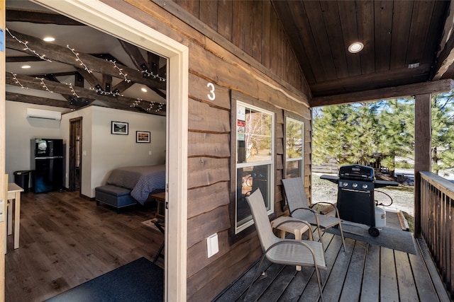 deck with an AC wall unit and grilling area