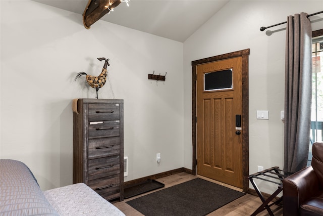 entryway featuring vaulted ceiling with beams