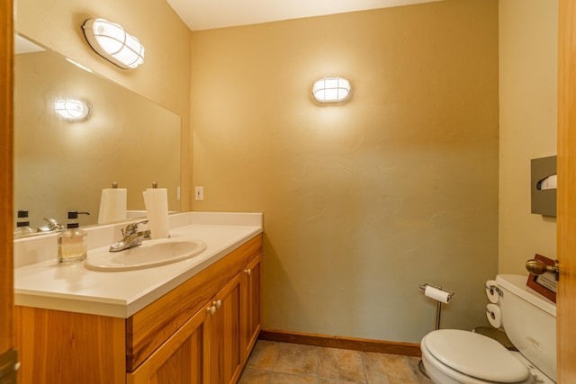 bathroom with toilet, tile flooring, and vanity