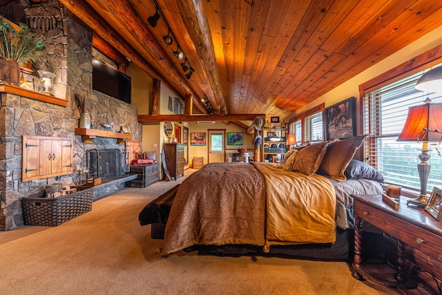 carpeted bedroom with beamed ceiling, a fireplace, and wood ceiling