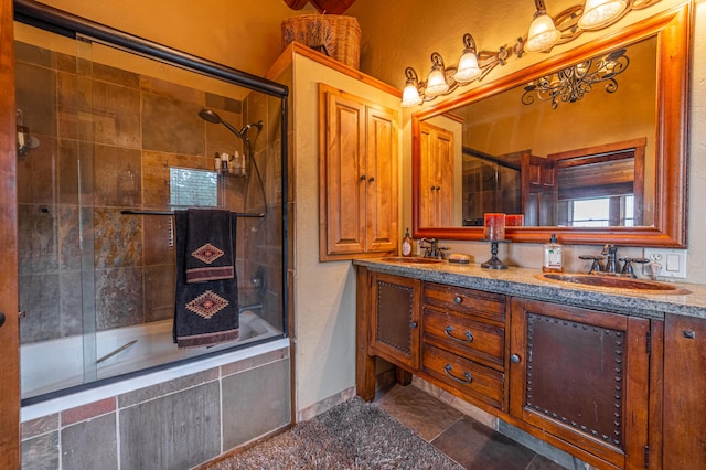 bathroom featuring a chandelier, dual bowl vanity, enclosed tub / shower combo, and tile flooring