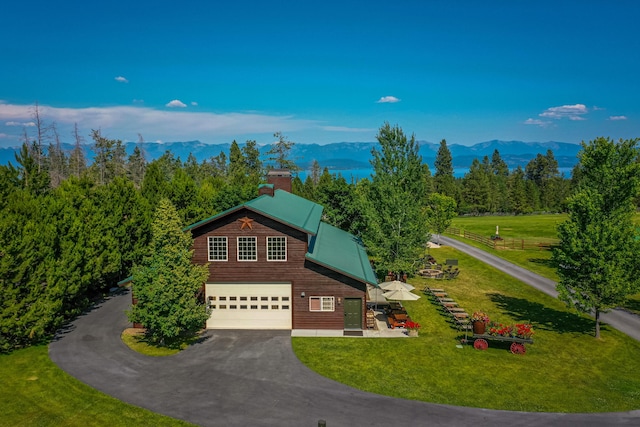 view of front of house with a front lawn, a mountain view, and a garage