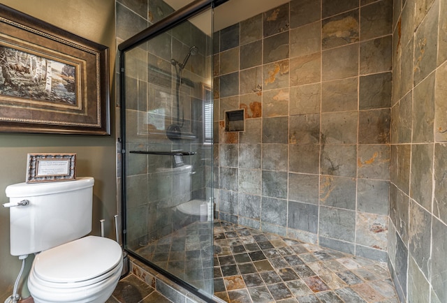 bathroom with a shower with door and toilet