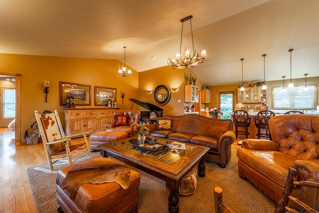 living room with vaulted ceiling, light hardwood / wood-style floors, and a notable chandelier