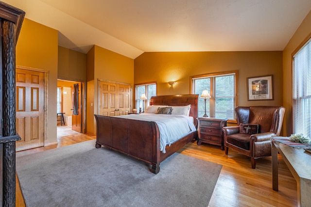 bedroom with vaulted ceiling and light wood-type flooring