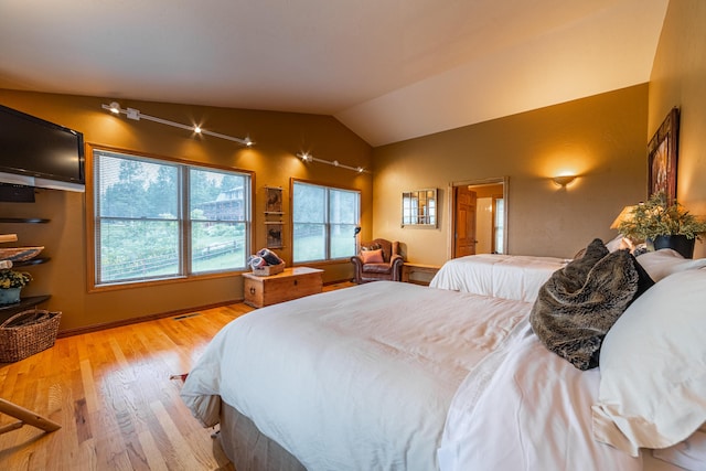 bedroom featuring vaulted ceiling and light wood-type flooring