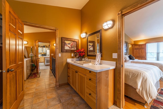 bathroom with tile flooring, vanity, and lofted ceiling