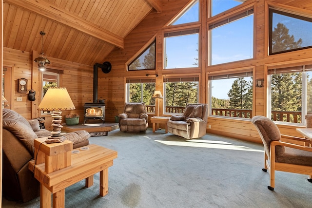 carpeted living room featuring wood walls, high vaulted ceiling, beamed ceiling, wooden ceiling, and a wood stove