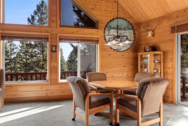 carpeted dining room with wood ceiling and high vaulted ceiling