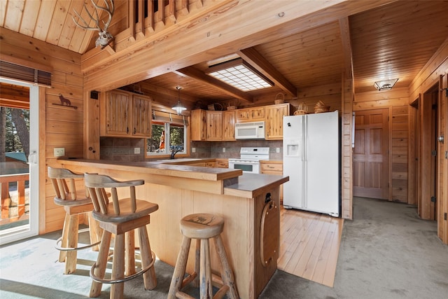 kitchen with wood ceiling, white appliances, light carpet, and kitchen peninsula