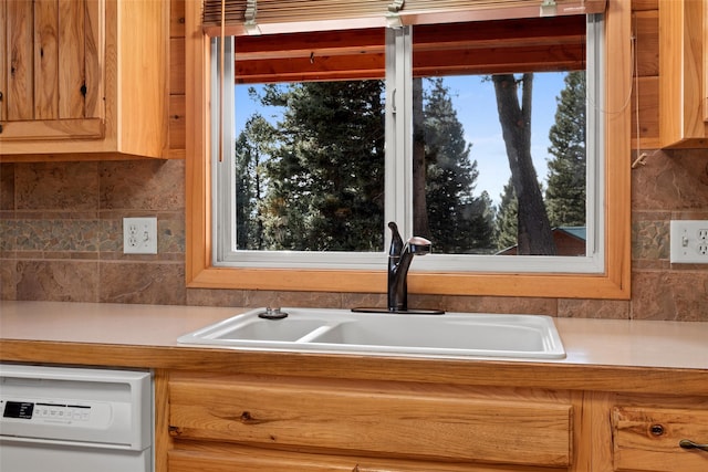 kitchen featuring a healthy amount of sunlight, sink, backsplash, and dishwasher