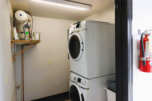 clothes washing area with stacked washer / dryer