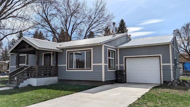 single story home featuring a chimney, an attached garage, a front yard, metal roof, and driveway