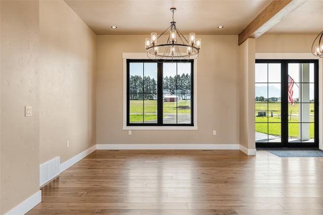 1052 Foxtail Dr, Kalispell, MT 59901 - unfurnished dining area featuring a chandelier, wood finished floors, visible vents, and beamed ceiling