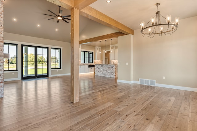 unfurnished living room with beamed ceiling, ceiling fan with notable chandelier, high vaulted ceiling, and light hardwood / wood-style floors