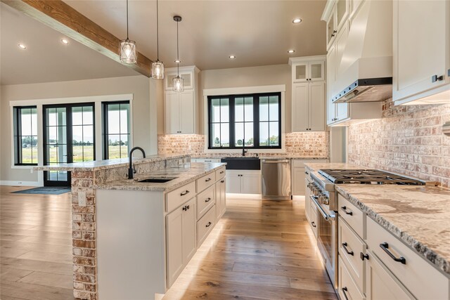 kitchen featuring premium range hood, stainless steel appliances, light hardwood / wood-style floors, and sink