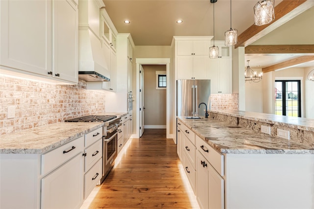1052 Foxtail Dr, Kalispell, MT 59901 - kitchen with recessed lighting, high end appliances, light stone counters, premium range hood, and light wood-style flooring