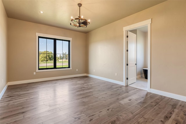 1052 Foxtail Dr, Kalispell, MT 59901 - spare room with baseboards, wood finished floors, and a chandelier