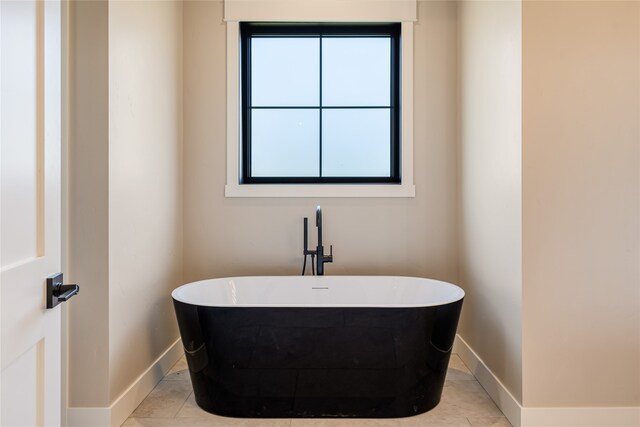 bathroom with tile patterned flooring and a washtub