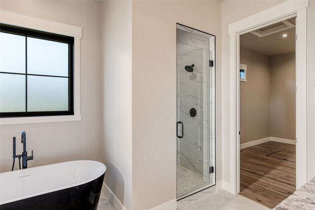 bathroom with hardwood / wood-style floors and independent shower and bath