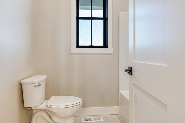 bathroom featuring a bath, toilet, and tile patterned floors