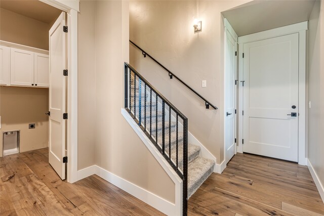 stairs featuring hardwood / wood-style floors